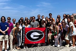 Group taking picture with UGA flag
